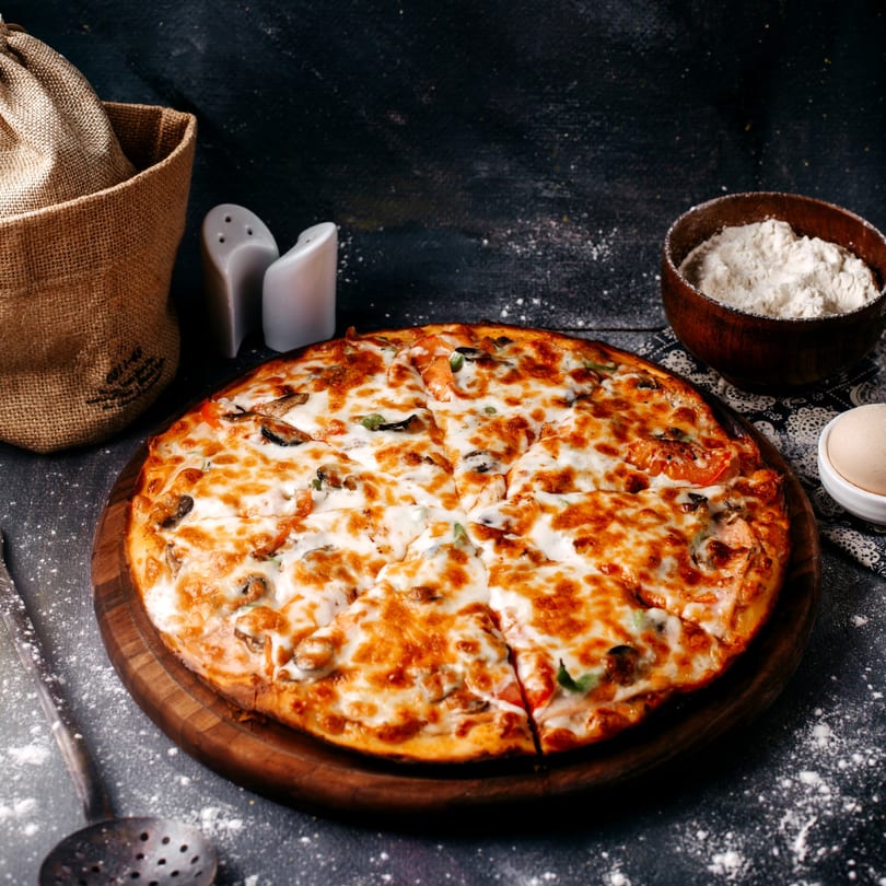 A Wacky Zaki's pizza with melted cheese and toppings, served on a wooden board.